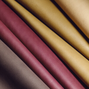 PU leather mimics real leather, offering durability and water resistance. Popular in bags, jackets, and upholstery for its affordability and versatility.